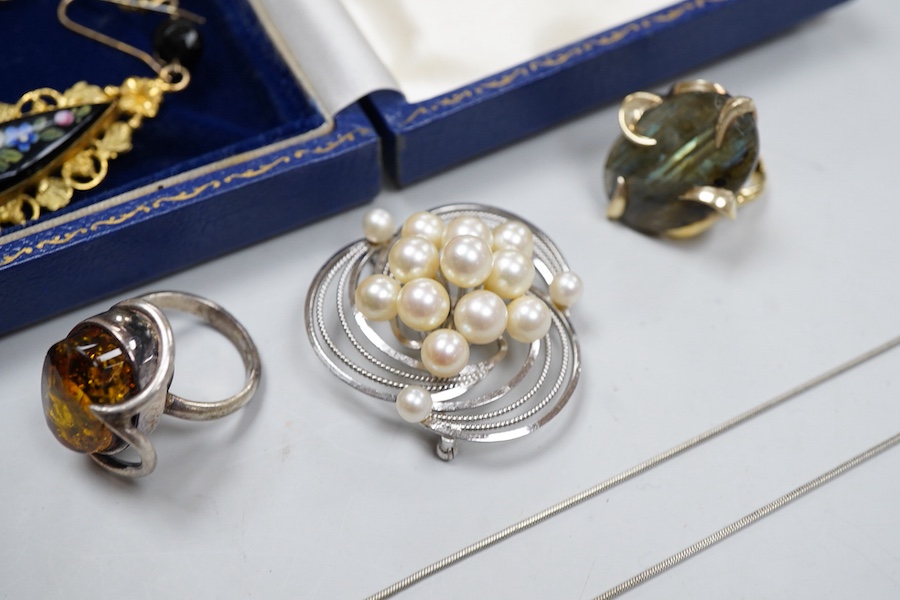 A collection of jewels, comprising: two amber pendants and an amber ring, each mounted in silver; a pair of gilt metal and enamel earrings of floral design; a pair of gilt metal earrings; a silver and cultured brooch; a